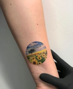 a person with a sunflower tattoo on their arm