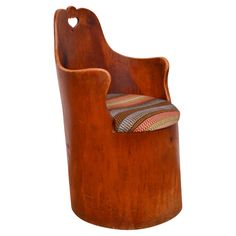 a wooden chair with a striped seat cushion on it's back and armrests