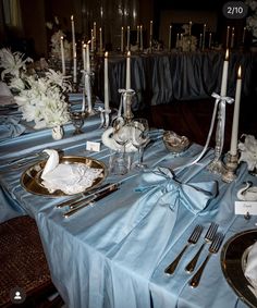 the table is set with silverware and white flowers