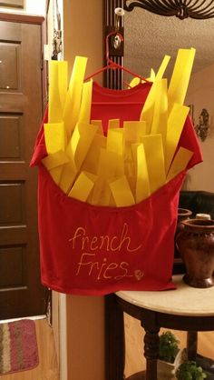 a red shirt with french fries written on it hanging from a hook in a hallway