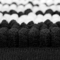 black and white photograph of several balls of yarn on top of each other in rows