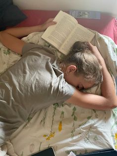 a person laying in bed with an open book