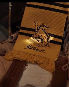 a yellow scarf with an image of a lizard on it and some scissors next to it