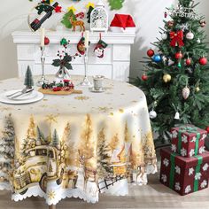 a table with a christmas scene on it next to a christmas tree and presents in front of a fireplace