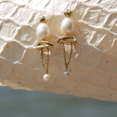 Elevated, edgy, feminine - Estel. The Estel earrings will enhance any day to night outfit so you can make a splash this summer. This set is carefully crafted with baroque pearls, organic gold shapes, and a classic Senia chain drape. Restocking. Pre- Order now (5-6 week lead time) Materials Plated 14k Yellow Gold with Sterling Silver Post, Baroque Pearls Measurements Width: 10 mm, Length: 30 mm Colored Gems, Gems Jewelry, Baroque Pearls, Night Outfits, Pure Silver, Precious Metals, Gold Vermeil, Solid Gold, 18k Gold