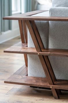 a wooden shelf sitting on top of a gray couch