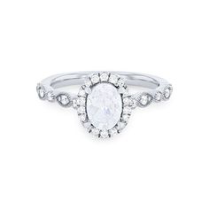 an oval shaped white diamond ring with diamonds around the band, set in 18k white gold