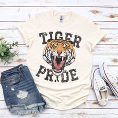 Show your love of the game with this vintage style Tiger Pride design on a super soft t-shirt. This is a fun distressed retro school spirit shirt for the games and everyday wear! It makes the perfect sports mom gift or teacher gift! This vintage school spirit tee is everything you've dreamed of and more. This vintage shirt is perfect for the season layered under your favorite cardigan! It feels soft and lightweight, with the right amount of stretch. It's comfortable and flattering for all. Show High School T Shirts, Tiger Mascot Shirt Ideas, High School Spirit Wear, School Sports Shirts, Tiger Tshirt, Tigers Shirt, Sports Mom Gifts, Tiger Mascot, Mascot Shirt