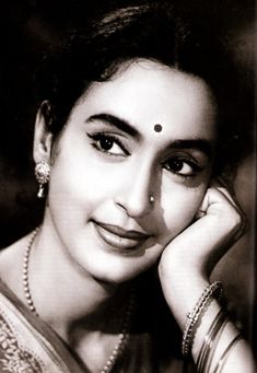 an old photo of a woman with her hands on her face and wearing pearls around her neck