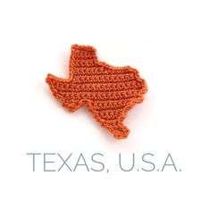 an orange crocheted texas state with the word texas usa written across it on a white background