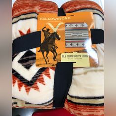 an orange and white blanket with a black ribbon around the edge that says yellowstone on it