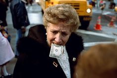 a woman with money in her mouth walking down the street