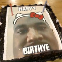 a close up of a cake with a photo of a person wearing a bow on it