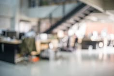 blurry image of an office building with stairs and desks in the foreground