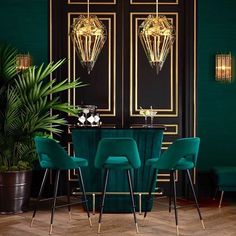 a dining room with green velvet chairs and gold chandelier