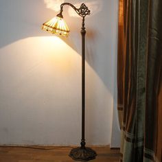 a lamp that is sitting next to a window with curtains on the side of it