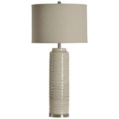 a table lamp with a beige shade on it and a white fabric lampshade