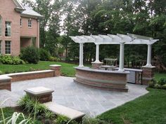 a brick patio with an outdoor kitchen and seating area