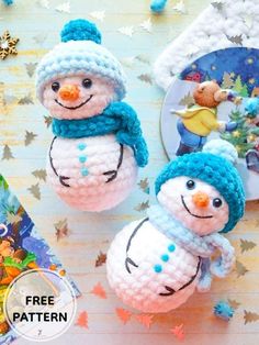 two crocheted snowmen with hats and scarfs on top of a table