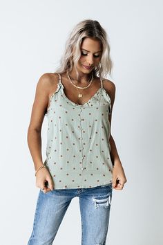 Keep your transitional style effortless with our pretty sage colored 'Napa Or Nothing' tank featuring lightweight material patterned with brown polka dots, a v-cut neckline and upper back with ruffle trim detailing, a button down front with adjustable spaghetti straps, and a relaxed silhouette that falls into a straight hemline!    Measurements S variant has  a Bust of 34",  a Hip of 40",  a Length of 23",  a Waist of 36".  M variant has  a Bust of 36",  a Hip of 42",  a Length of 24",  a Waist V-neck Floral Print Tank Top For Beach, Chic V-neck Floral Print Tank Top, Spring V-neck Ruffled Tank Top, Floral Print V-neck Tank Top For Beach, Chic Floral Print V-neck Tank Top, Singlet Tops, Brown Polka Dots, Womens Camisoles, V Cut