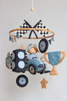 a toy car is hanging from the ceiling in front of a white wall with black and blue decorations