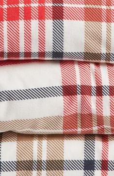 three plaid sheets are stacked on top of each other, one is red and the other is white