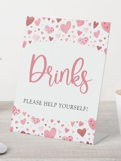 a sign that says drinks please help yourself with hearts on the front and back of it