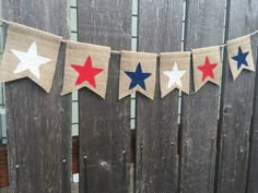 an american flag bunting is hanging on a fence with red, white and blue stars