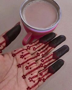 a person's hand with hendix on it next to a cup of coffee