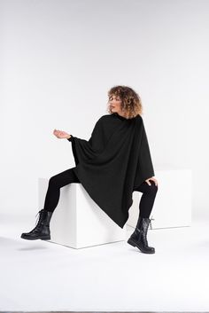 "Super warm asymmetrical knitted poncho. The model in the picture is 176cm. ⅼ 5.8 ft. tall and is wearing size S / color: Black 🌟 INFO: * Worldwide EXPRESS shipping - please provide a phone number for shipping documents * US Sizing XS to 4XL - size chart available below - all measurements of the body * We offer customization to Personal Measurements & Larger Sizes 5XL, 6XL, 7XL .... 🌟 MATERIAL & CARE * fabric: acrylic wool-cotton mix * hand wash * cold water 30 degrees * iron at medium Black Knitted Poncho One Size, Black Knitted One-size Poncho, Black Shawl Poncho One Size, Black Poncho With Batwing Sleeve, Oversized Knit Winter Cape, Black Cape Cardigan For Winter, Black Poncho With Batwing Sleeve One Size, Black Knit One-size Poncho, Oversized Winter Knit Cape