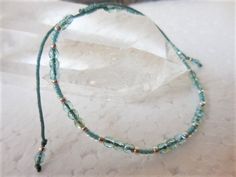 "This sparkly turquoise beaded bracelet or anklet, which I call Fire Polish Slider, is made with small Czech fire polish beads in light aqua AB, turqoise seed beads, silver seed beads and is strung on beautiful and durable nylon cord in Sea Green and finished with a small sliding knot. The bracelet fits a 6\" wrist comfortably when all the way closed, and has enough cord to open up to 9.5\". The anklet fits an 8\" anklet comfortably and opens up to 12\" to go over the foot. When closed completel Adjustable Turquoise Crystal Bracelet Hand-strung, Adjustable Turquoise Friendship Bracelets With Tiny Beads, Adjustable Green Anklets With Tiny Beads, Adjustable Beaded Anklet As A Gift, Adjustable Turquoise Anklet With Tiny Beads, Adjustable Turquoise Anklets With Round Beads, Adjustable Beaded Anklets With Round Beads, Adjustable Turquoise Crystal Bracelet With Faceted Beads, Adjustable Hand-strung Anklets With Round Beads