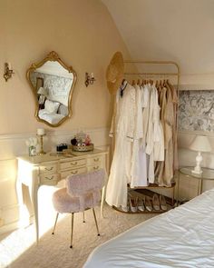 a bedroom with a bed, dresser and dressing table in the corner next to a mirror