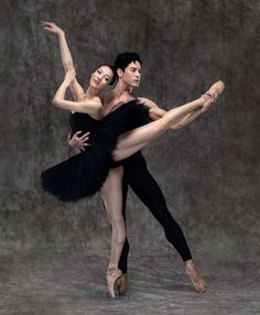 two ballerinas in black tutus are posing for the camera