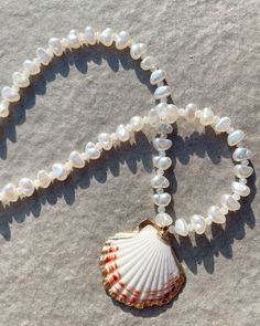 Shell & pearl necklace. One size fits all - 20 inches. Handle with care, avoid wearing in water. Elegant Pearl Charm Necklace For Beach, White Shell-shaped Pearl Drop Necklace, Elegant Beach Pearl Necklace With Pendant, Elegant Pearl Necklace With Charm For Beach, Shell-shaped Pearl Necklace With Pearl Pendant, Shell-shaped Pearl Charm Necklaces, Beach Pearl Drop Necklaces, Pearl Strand Jewelry With Charm, Pearl Strand Jewelry With Pearl Charm