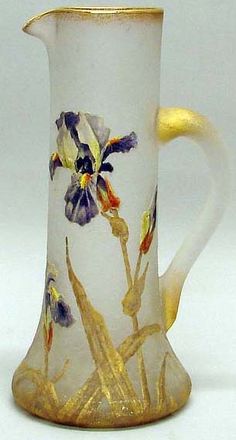 a glass pitcher with flowers painted on it