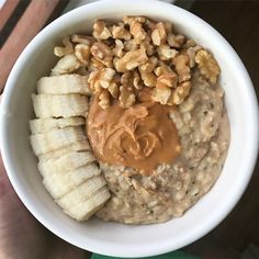 a white bowl filled with oatmeal, bananas and peanut butter on top