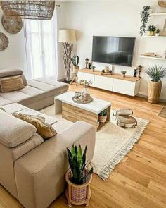 a living room filled with furniture and a flat screen tv on top of a wooden floor