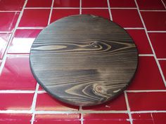 a wooden plate sitting on top of a red tiled floor