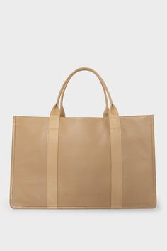 A large beige tote bag with a rectangular body and a magnetic closure. The bag has 2 handles to be carried handheld or as a shoulder bag. Beige Tote Weekender Bag For Shopping, Beige Weekender Bag For Shopping, Shopping Weekender Tote Bag With Top Carry Handle, Weekender Tote Bag With Top Carry Handle, Weekender Tote Bag With Top Carry Handle For Shopping, Classic Beige Weekender Bag With Double Handle, Large Classic Satchel For Shopping, Beige Leather Weekender Bag For Shopping, Classic Weekender Bag With Large Capacity For Shopping