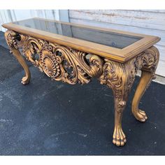 an ornate wooden table with glass top