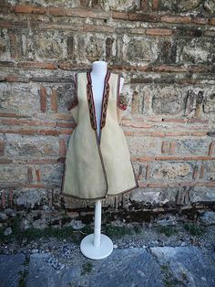 This is a a long vest, also known as 'klashenik' and also as 'resacka' part of the women's ethnic costume from the south western part of Macedonia, Struski Drimkol. This vest was made in the second half of XIX century and is really rare piece of the ethnic costume from this region. The vest has a few damages visible on the photos, a hole at the back side, few damages on the embroidery on the sleeves and a discoloring from washing on some places and that's the reason the price is much lower than Fitted Folk Style Vest For Festive Season, Traditional Fitted Vest For Fall, Traditional Fitted Fall Vest, Handmade Folk Style Vest For Festivals, Traditional Sleeveless Vest Outerwear, Traditional Ceremonial Sleeveless Vest, Fitted Folk Style Festive Vest, Handmade Folk Vest For Festivals, Festive Folk Style Fitted Vest