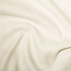 an unmade bed with white sheets and pillows