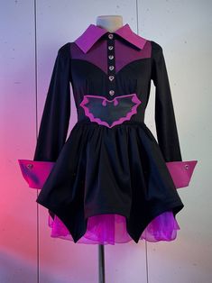 a dress with purple and black trims on a mannequin headdress