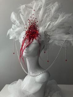 a white mannequin headdress with feathers and beads on it's head