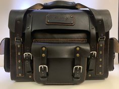 a black leather bag sitting on top of a white table