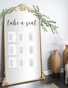 a wedding seating chart on a mirror next to vases