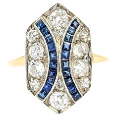 Old Mine Cut Diamond & Sapphire Shield Ring in Yellow Gold Introducing this beautiful Antique Ring, crafted in 18kt two-tone white and yellow gold. The ring features a .85ctw Old Mine Cut diamond centerpiece, accented by .20ctw sapphires in a shield ring design. The sparkling diamonds are VS-SI clarity and near colorless, enhancing the overall brilliance of the piece. Old Mine Cut diamonds, popular in the 1910s, are known for their unique charm and historical significance. These diamonds symboli Antique Rings Victorian, Diamond Centerpiece, Shield Ring, Vintage Cocktail Ring, Old Mine Cut Diamond, Art Deco Diamond Rings, Jewellery Sketches, Antique Ring, Sapphire Diamond Ring