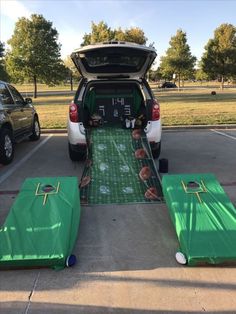 the back end of a car with an inflatable football field and picnic table