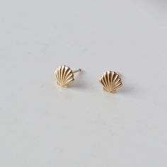 Cute little Shell studs are great alone or for your ear layering game. 14K Gold Filled These are sold as a set of 2 earrings6mm Gold Filled has 100 times more gold than gold plated jewelry. Gold filled wire is created by taking a sheet of 14 karat gold and bonding it through extreme heat and pressure to a core of semi-precious metal (brass). This is a very sophisticated process and only a few mills in the world do it. You should not mistake this process for gold plating as there is a very big di Trendy Gold Earrings Studs, Cute Little Earrings, Gold Shell Earrings, Ear Layering, Silver Braided Ring, Teen Christmas Gifts, Preppy Jewelry, Art Jewelry Design, Summer Earrings