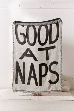 a black and white tapestry with the words good at naps printed on it's side